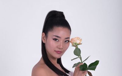 A person in a balanced stance on one leg in a bright, open space.